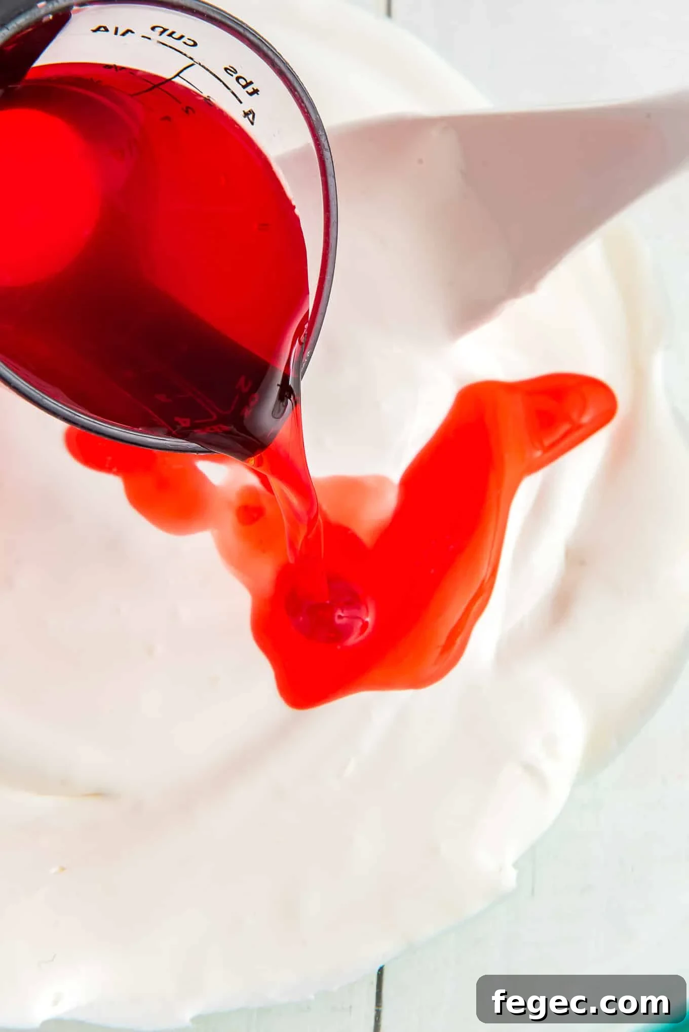 Mixing the cherry juice with the whipped topping.