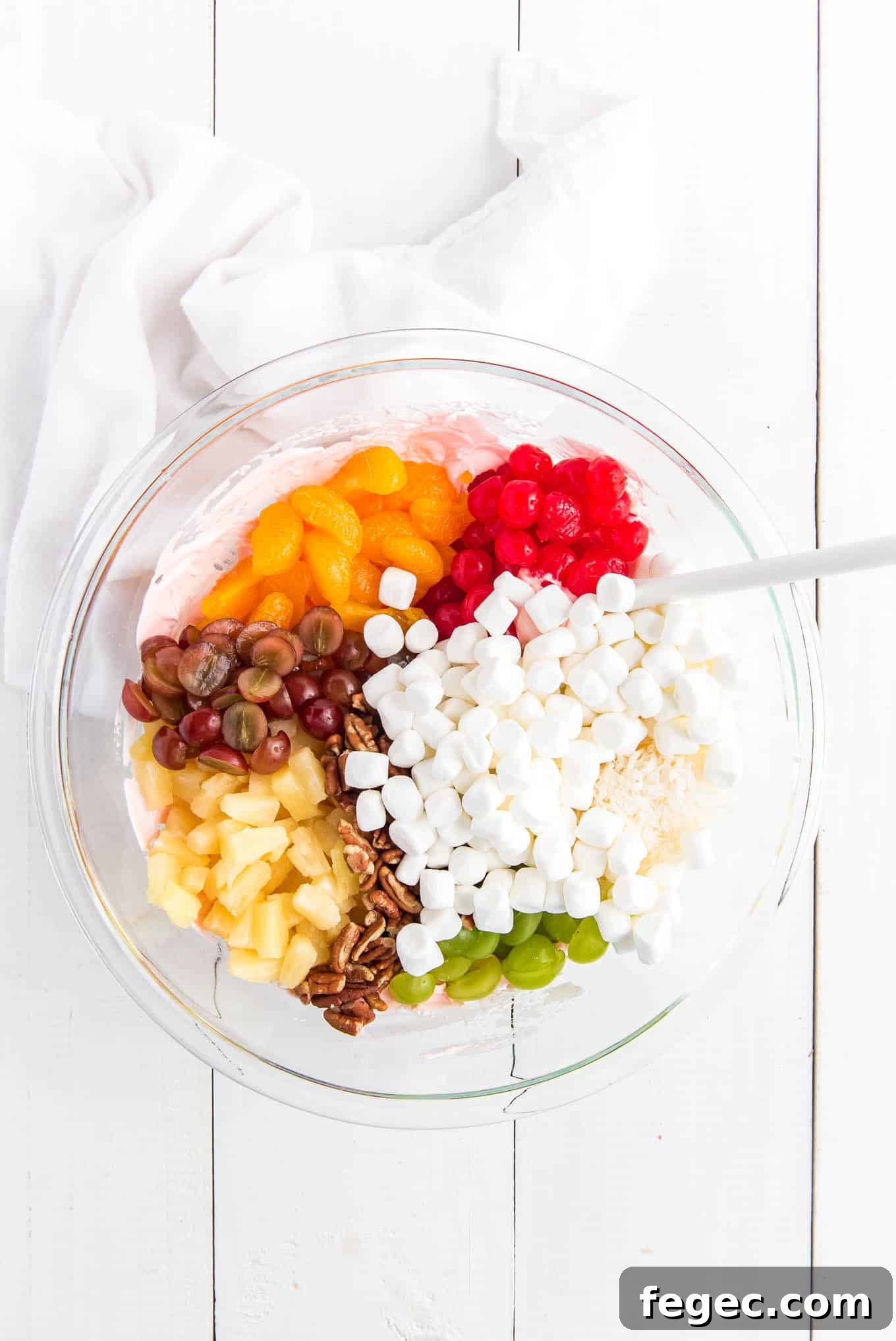 All the fruits, nuts and pecans in a bowl.