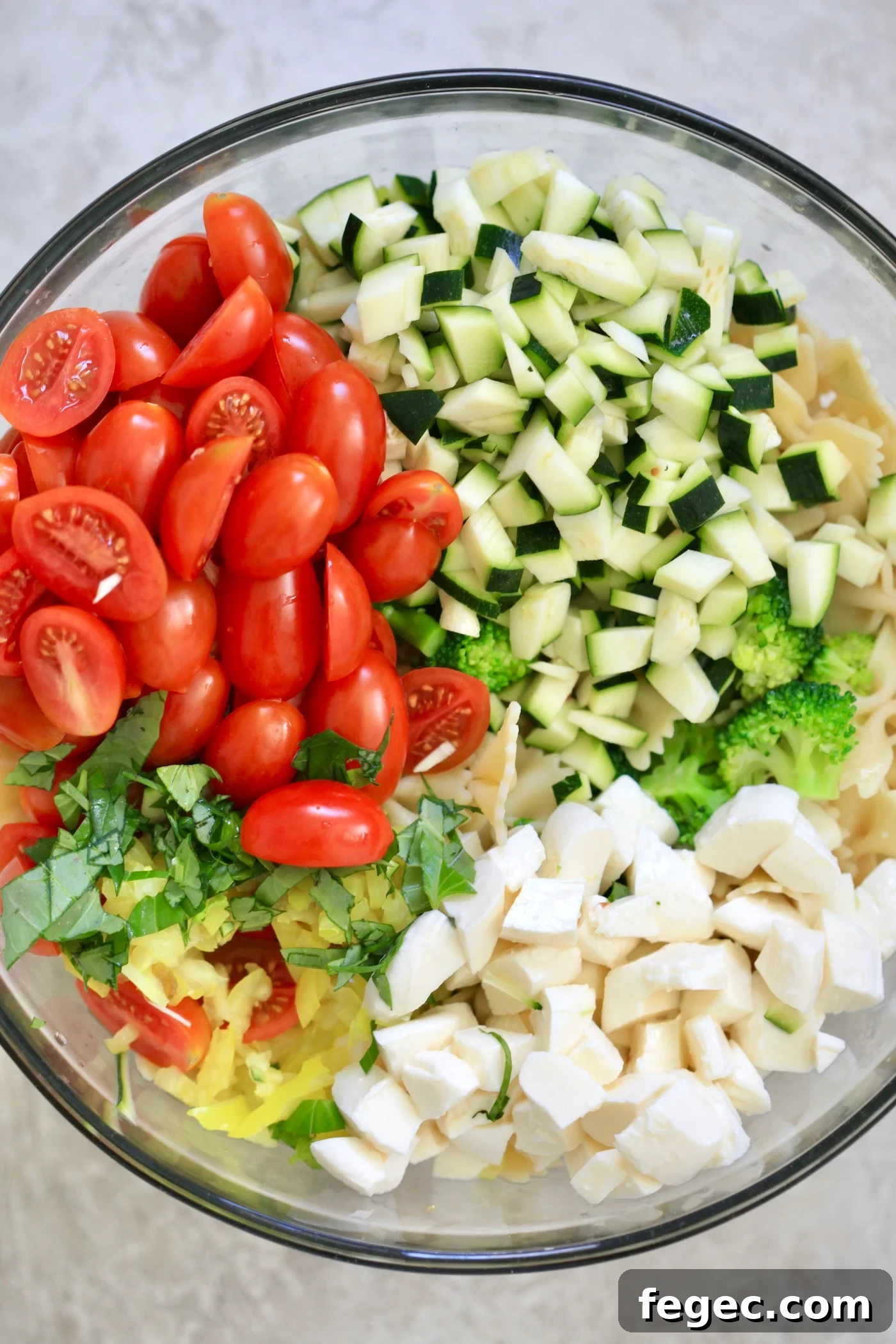 tomatoes, zucchini, cheese, and pasta in bowl