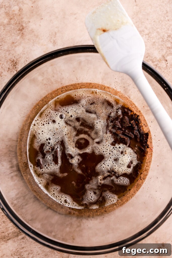 Butter and chocolate in a  glass bowl with a spatula. 