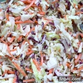 Creamy southern coleslaw (shredded carrots & cabbage covered in mayonnaise) up close.