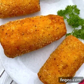 Pieces of deep fried corn on the cob on a white plate.