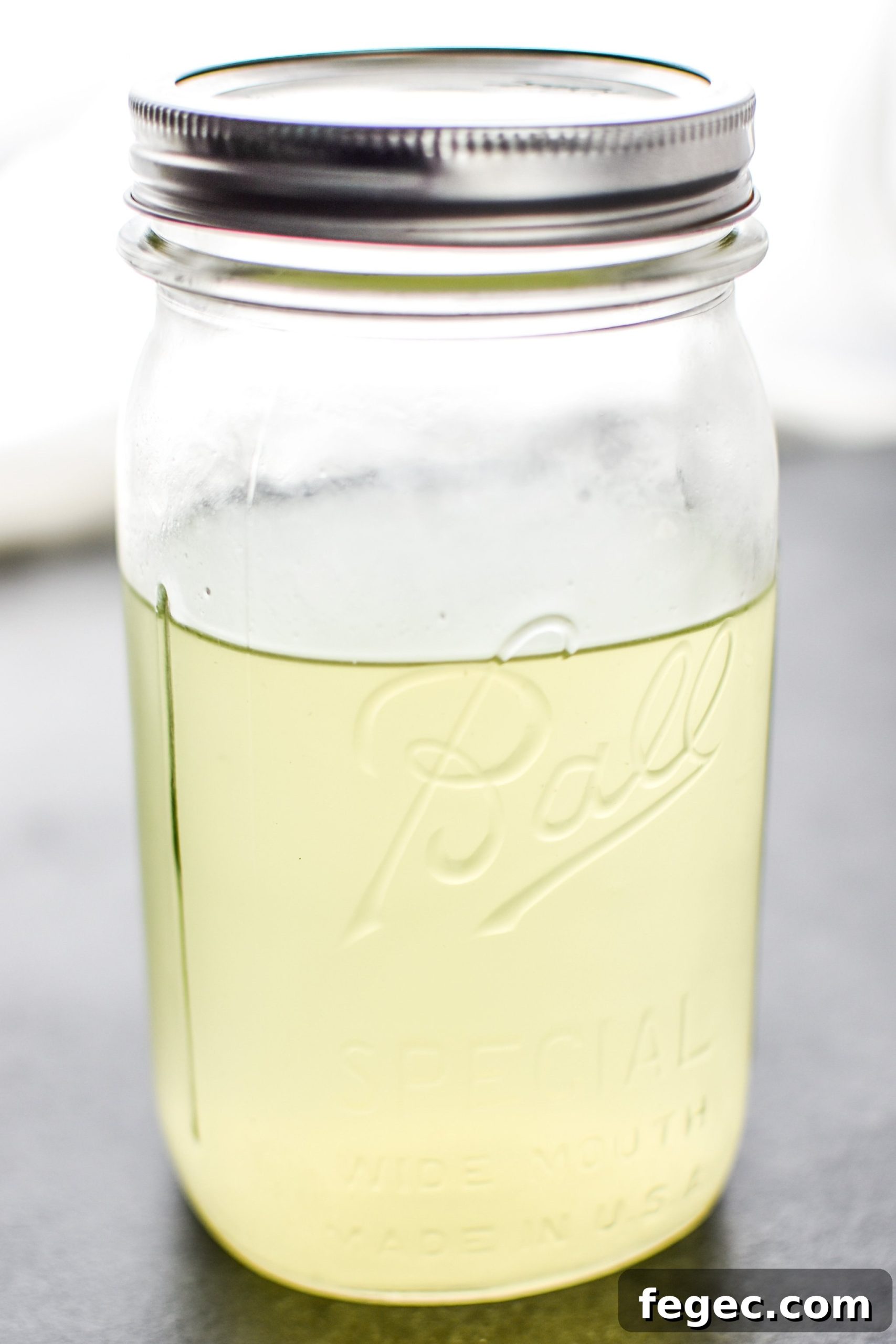 A jar full of leftover whey that has drained off yogurt to create Greek yogurt.