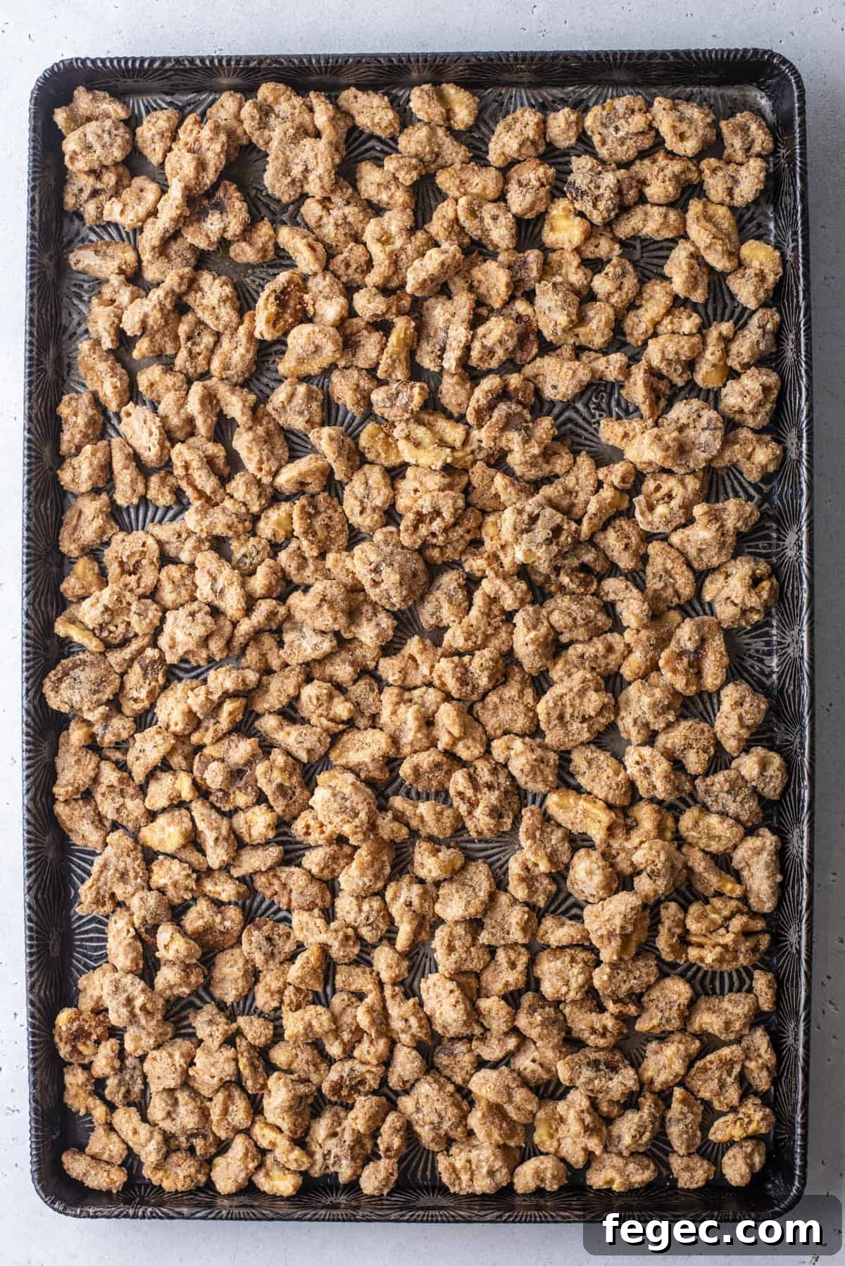 candied walnuts spread out over a baking sheet