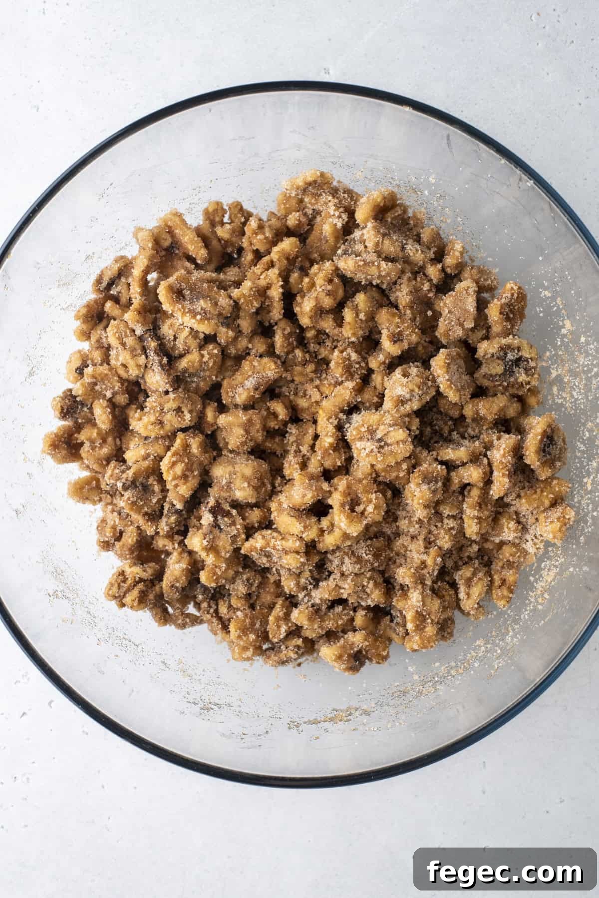 walnuts coated in a cinnamon sugar mixture in a glass bowl