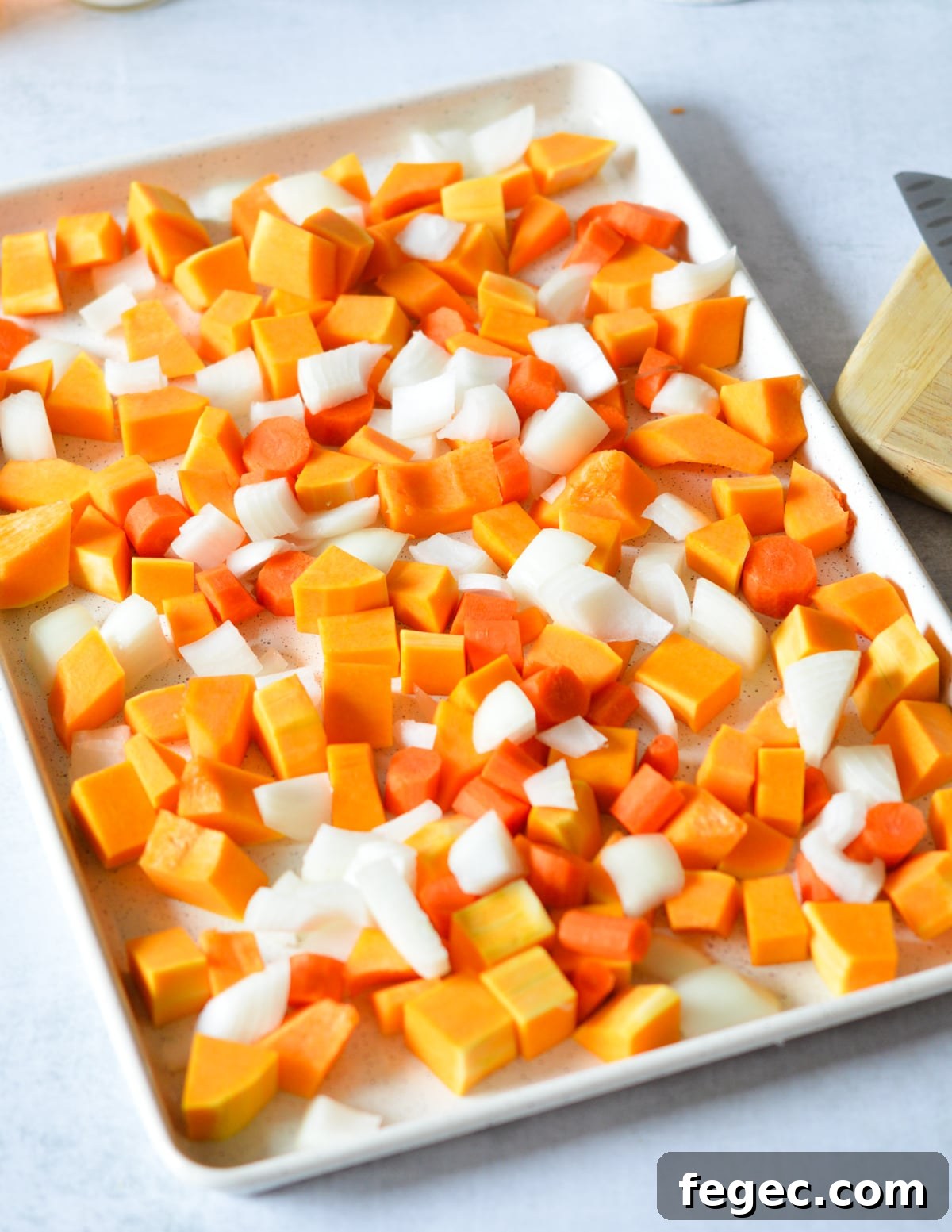 Creamy Roasted Butternut Squash Soup with Sage and Brown Butter 7 butternut squash, onion, and carrots on a sheet pan.