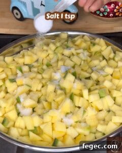 Chopped raw mangoes with salt and spices for Kerala style mango pickle.
