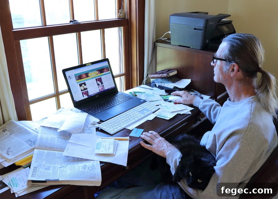 Plan Your Garden Now: How to Choose and Buy Seeds for Success 5 Jamie sitting at his desk with out cat on his lap, using his computer to order seeds