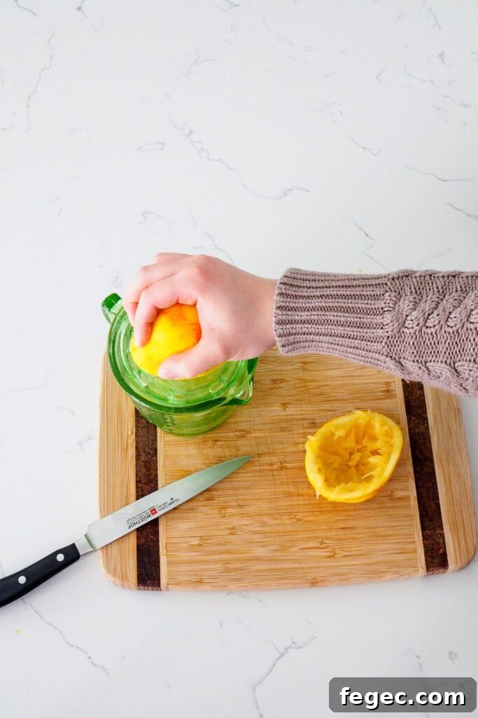 A hand squeezes fresh orange juice.