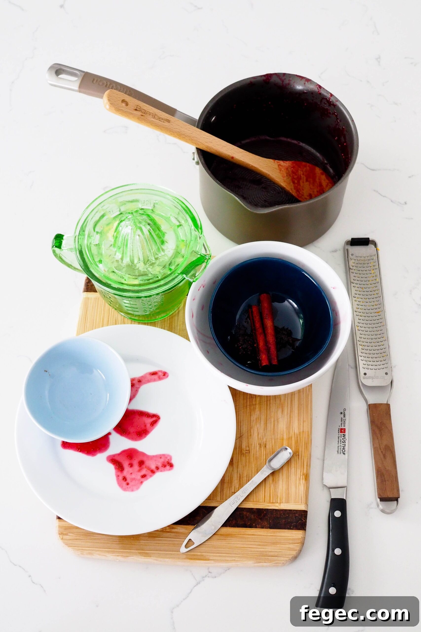 A collection of dishes used in making cranberry orange sauce.