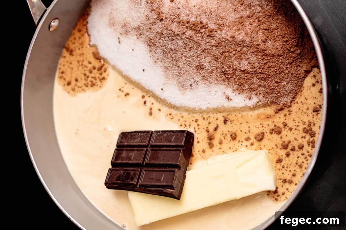 a chocolate bar, a stick of butter, and more hot fudge ingredients assembled in a pot