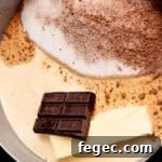a chocolate bar, a stick of butter, and more hot fudge ingredients assembled in a pot