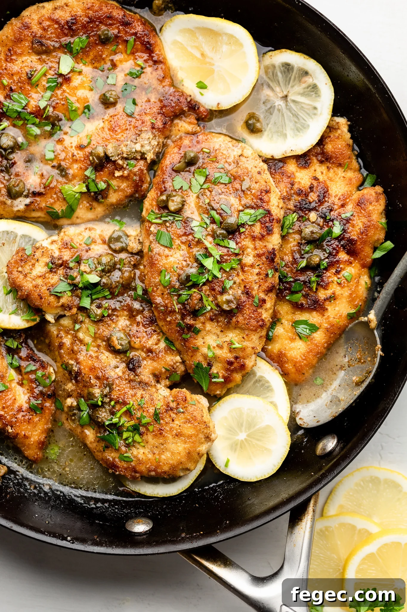 Gluten-Free Chicken Piccata with Lemon Caper Sauce 7 a skillet with gluten free chicken piccata, capers, lemon slices, and parsley