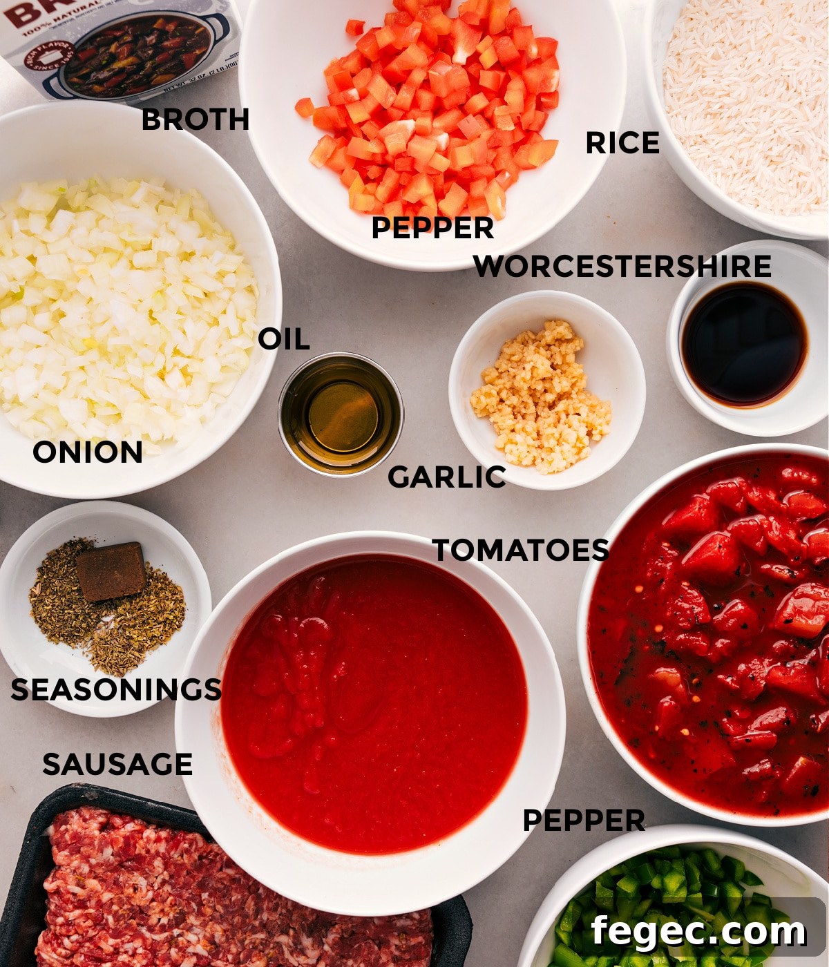 All the ingredients for this recipe are prepped and ready for easy assembly: peppers, onions, tomatoes, broth, meat, seasonings, garlic, Worcestershire, rice, and oil.