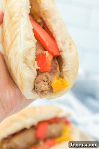 Close-up of sausage and peppers in hoagie bun.