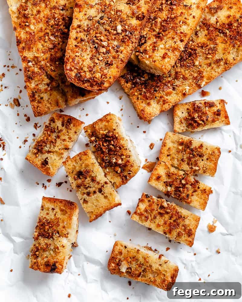 Crispy Vegan Garlic Bread Recipe You’ll Love 2 several Easy Vegan Garlic Bread pieces on white surface