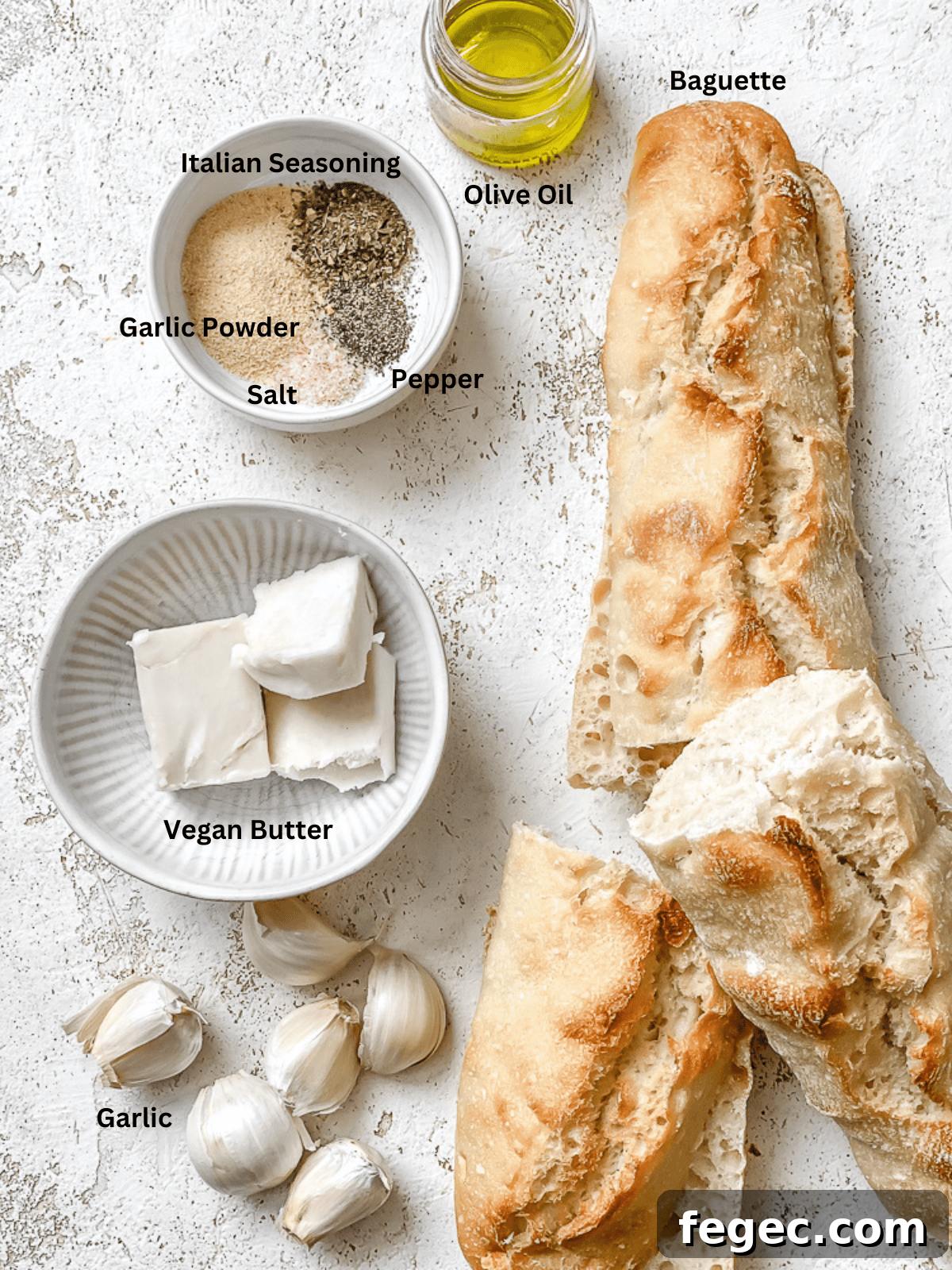 Crispy Vegan Garlic Bread Recipe You’ll Love 3 ingredients for Easy Vegan Garlic Bread on a white surface