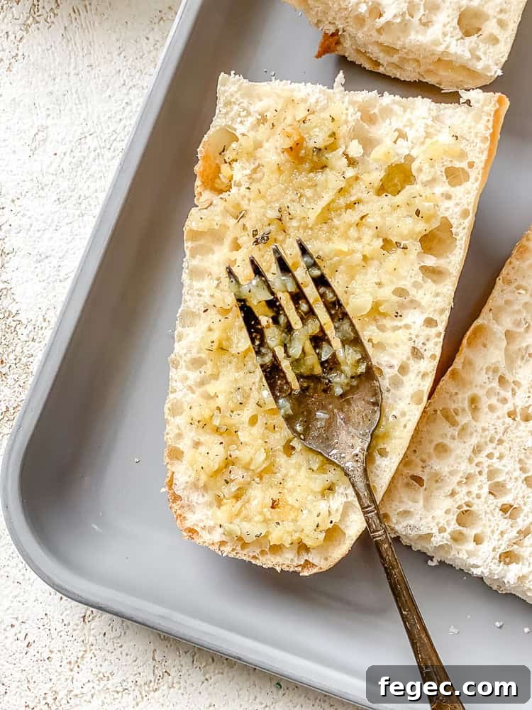 Crispy Vegan Garlic Bread Recipe You’ll Love 7 process shot showing spreading vegan butter mixture onto bread