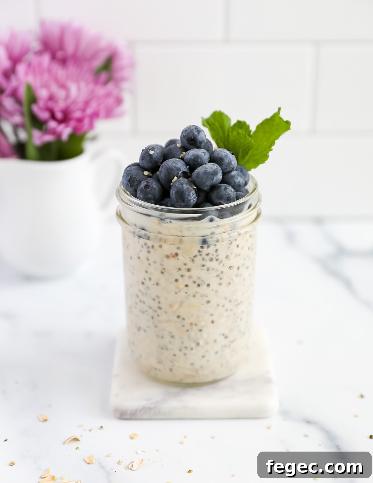 Creamy Chia Seed Overnight Oats Recipe for Busy Mornings 2 A picture of a jar of oatmeal with blueberries and mint on top
