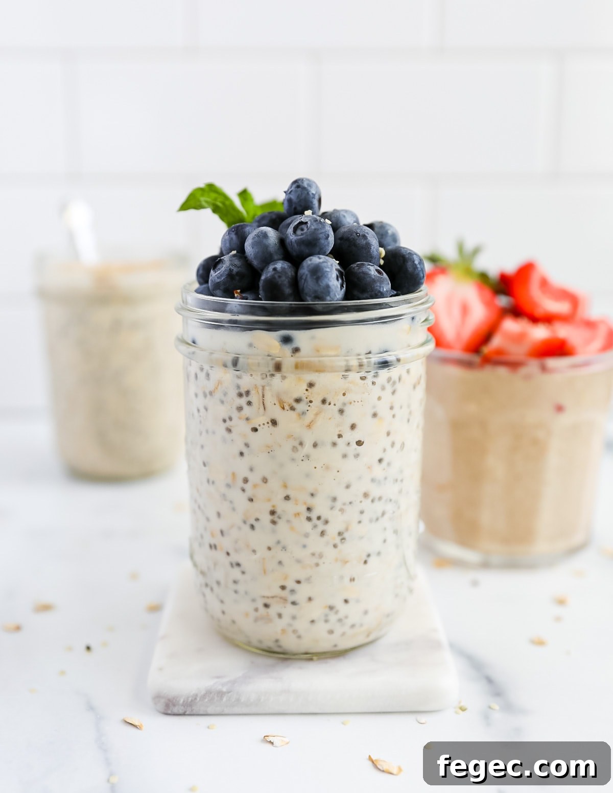 Creamy Chia Seed Overnight Oats Recipe for Busy Mornings 5 A picture of three different jars filled with overnight oatmeal with chia seeds. They are topped with fresh berries