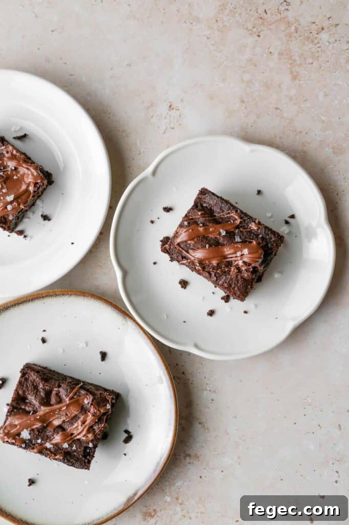 three plates with gluten free triple chocolate brownies that are drizzled in milk chocolate