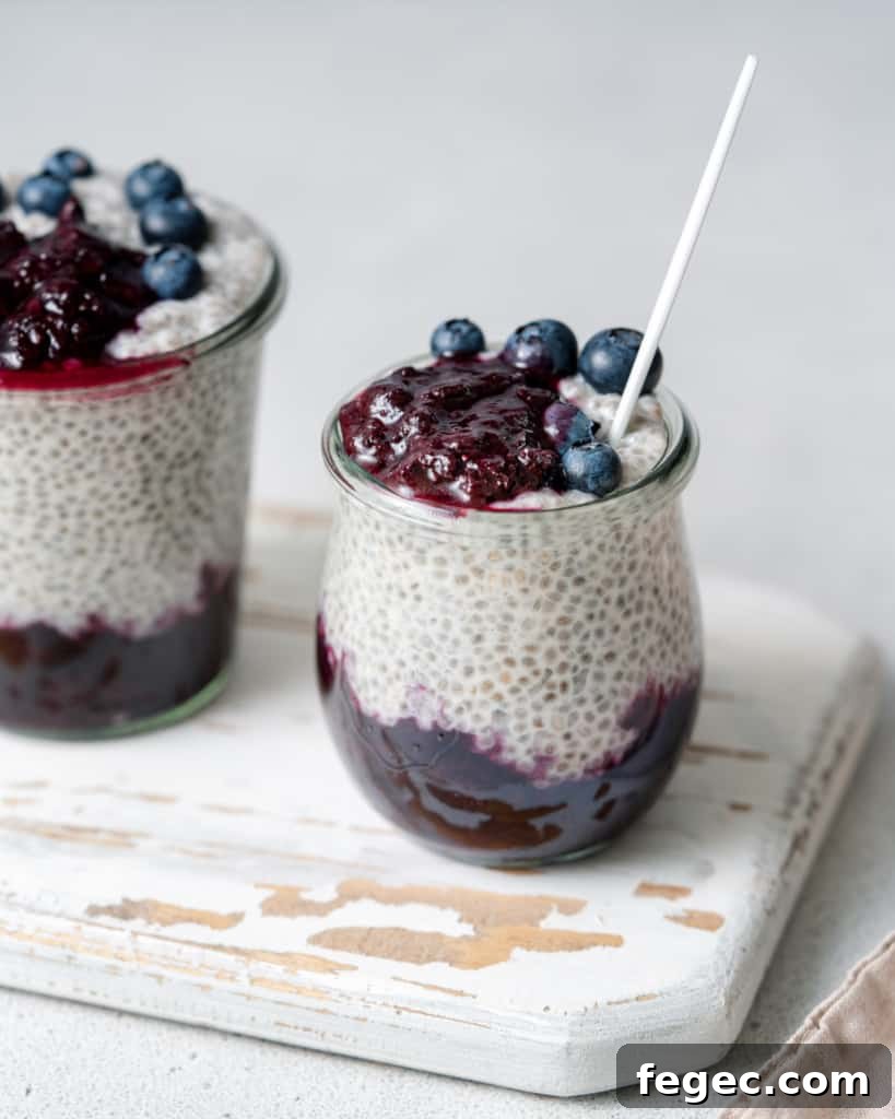 Chia seed pudding layered with blueberry sauce in small glass jars.