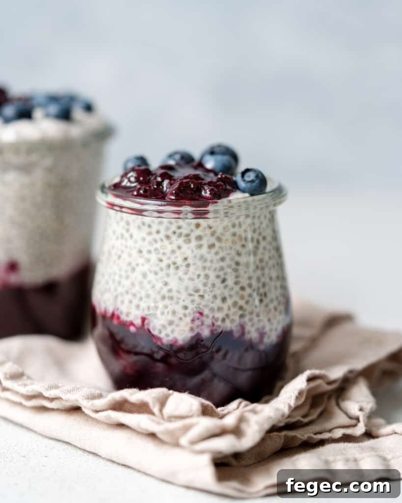 close up side shot of chia pudding in a jar with blueberry jam at the bottom