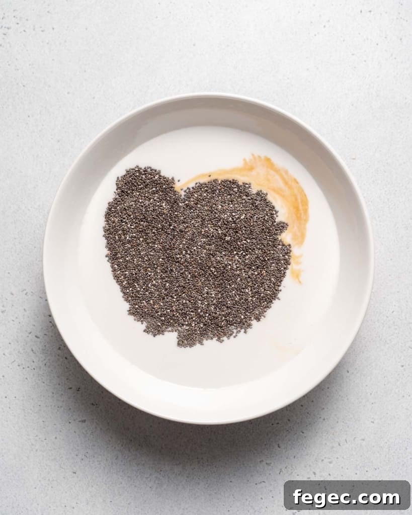 Chia seeds mixed with milk, vanilla and honey in a white bowl.