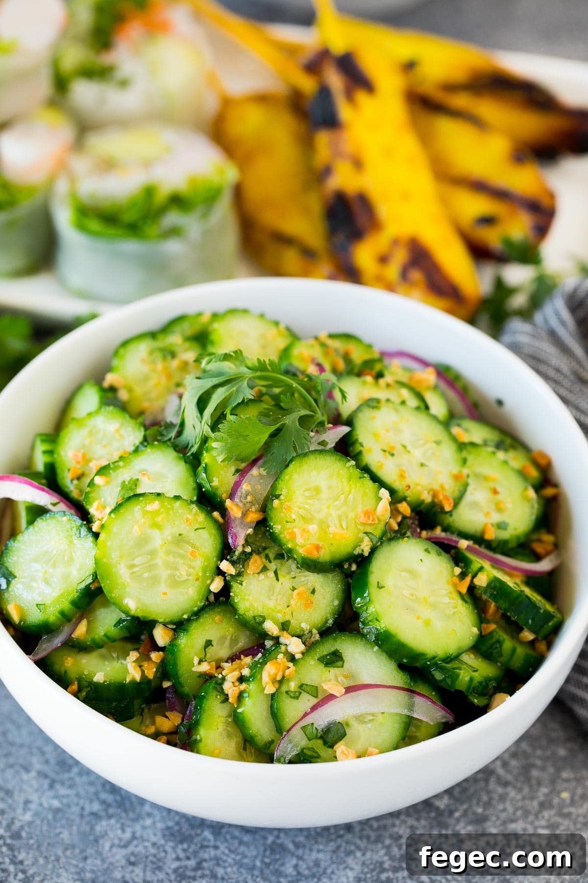 A bowl of Thai cucumber salad topped with peanuts and cilantro.