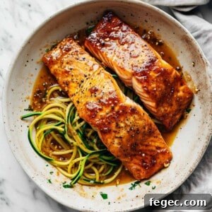 Maple glazed salmon in a pan with zucchini noodles.