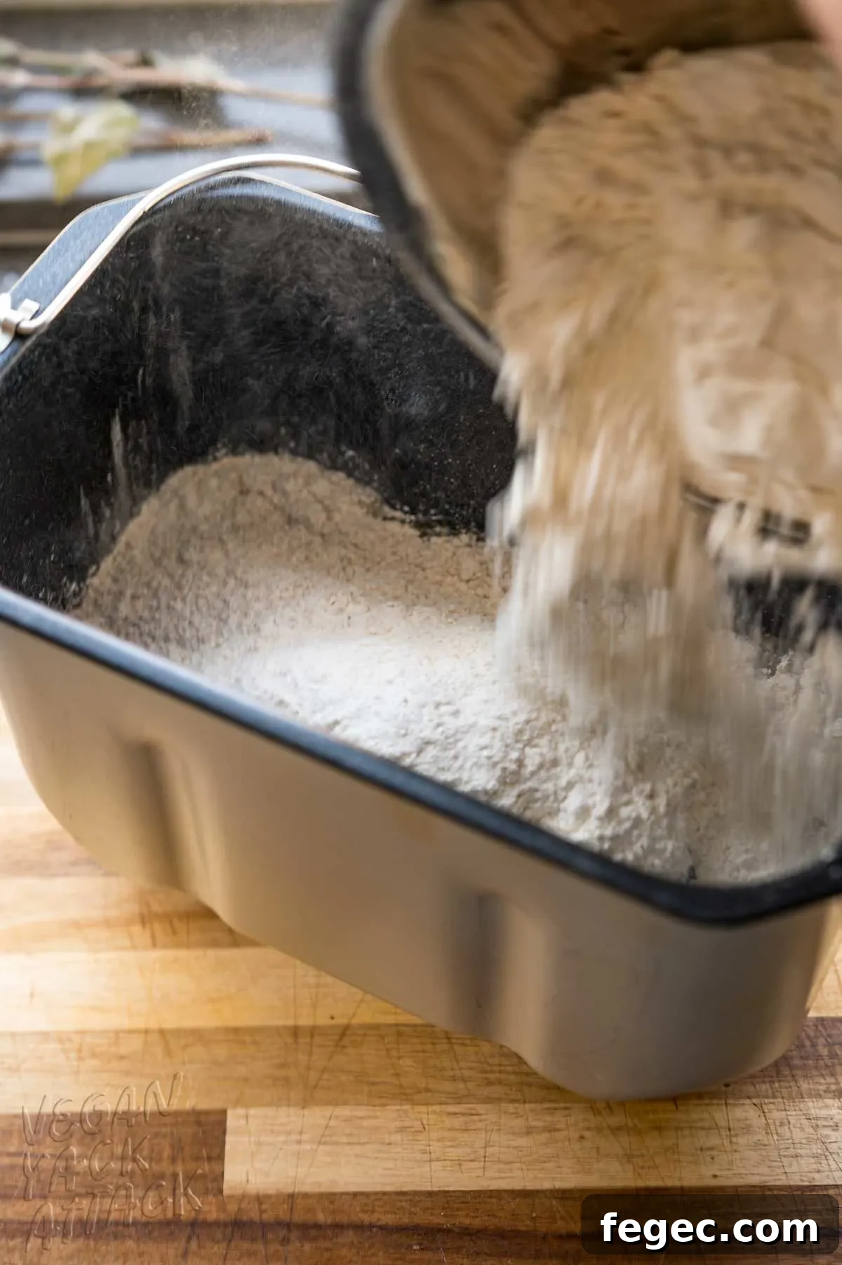 flour being added to bread machine pan
