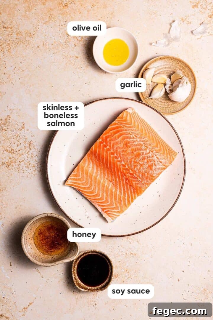 Labeled photo of ingredients in air fryer salmon bites, displayed in small bowls on a beige counter top.