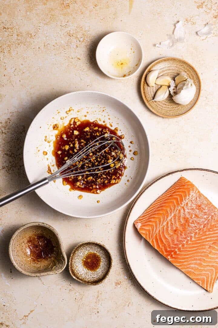 Marinade for air fryer salmon bites being whisked in a small white bowl.