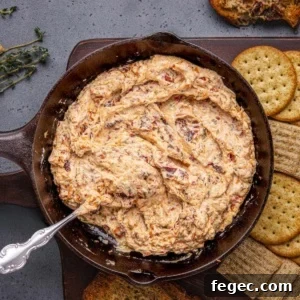 Creamy Baked Boursin Cheese Dip Recipe for Parties 13 Baked Boursin dip with crackers on a wooden board.