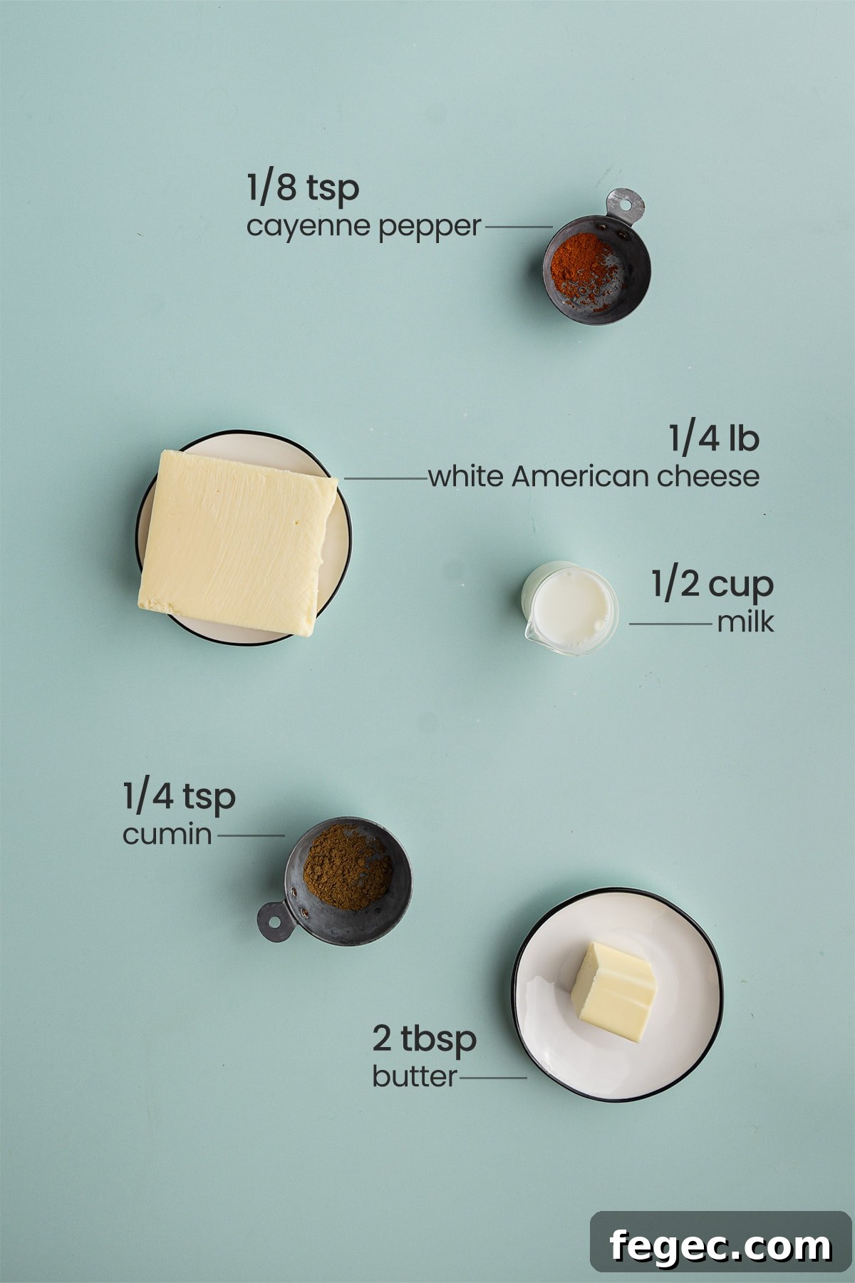 All 5 ingredients for Tex-Mex Queso Blanco including cayenne pepper, white American cheese, milk, cumin, and unsalted butter