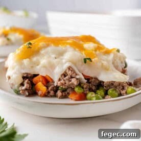 Slice of shepherd's pie on a white plate.