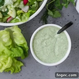 Overhead view of green goddess dressing in a small white bowl.