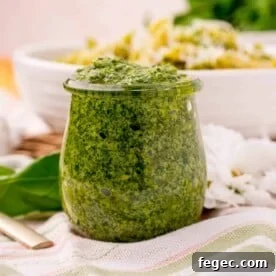 Straight on view of pesto in a glass jar.