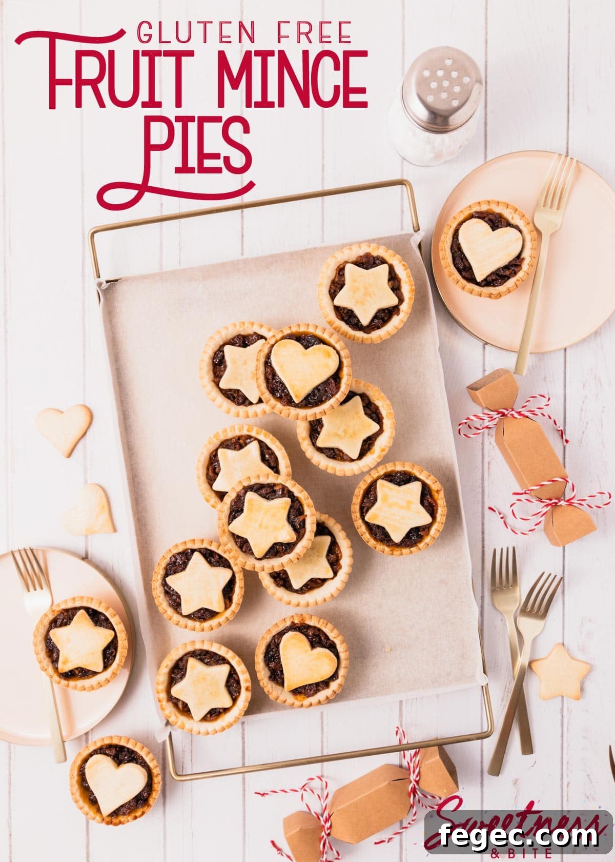 Mince pies arranged haphazardly on a gold metal tray, with pink and gold plates and gold cake forks, red text overlay reads 'gluten free fruit mince pies'.