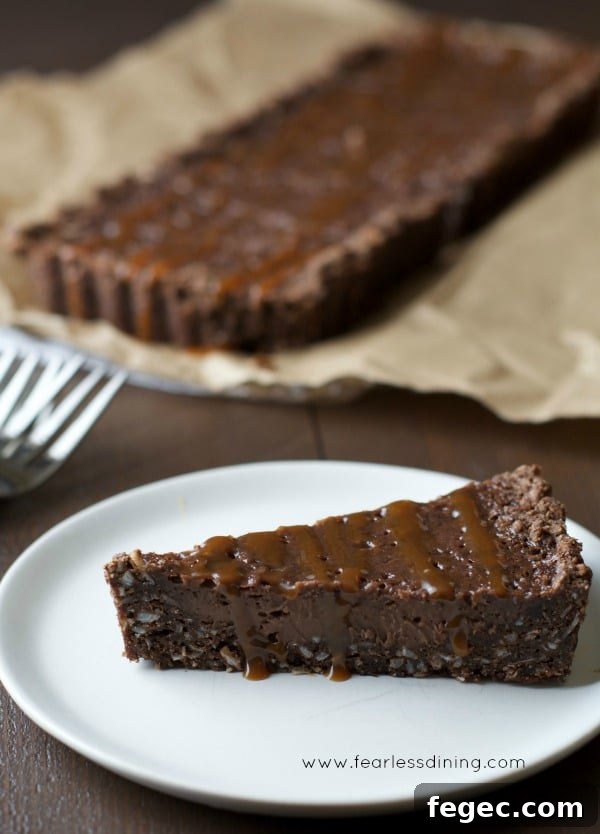 Gluten Free Chocolate Caramel Tart slice on a plate.