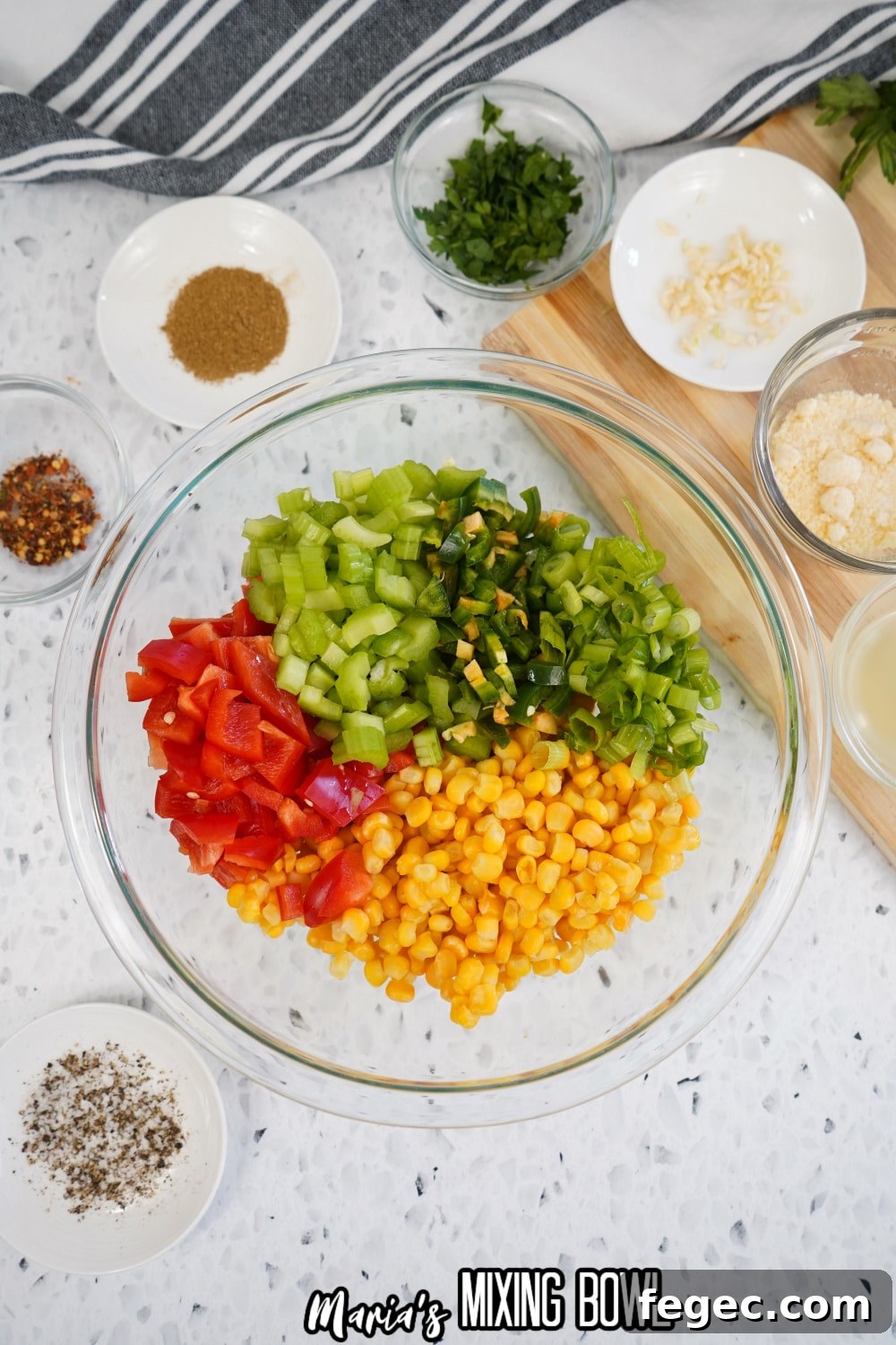 tomatoes, celery, jalapeno, green onions and corn in a glass mixing bowl