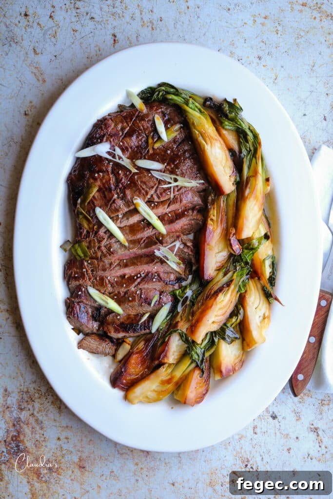 Asian-Marinated Grilled Flank Steak Recipe 2 Asian marinated grilled flank steak on white platter with stir fried bok choy