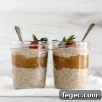 High-Protein Overnight Oats — 5-Ingredient Recipe 11 Two mason jars filled with overnight oats and almond butter topped with a strawberry.