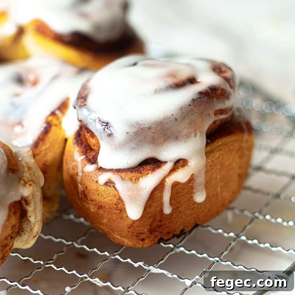 air fryer cinnamon roll topped with icing on a wire rack