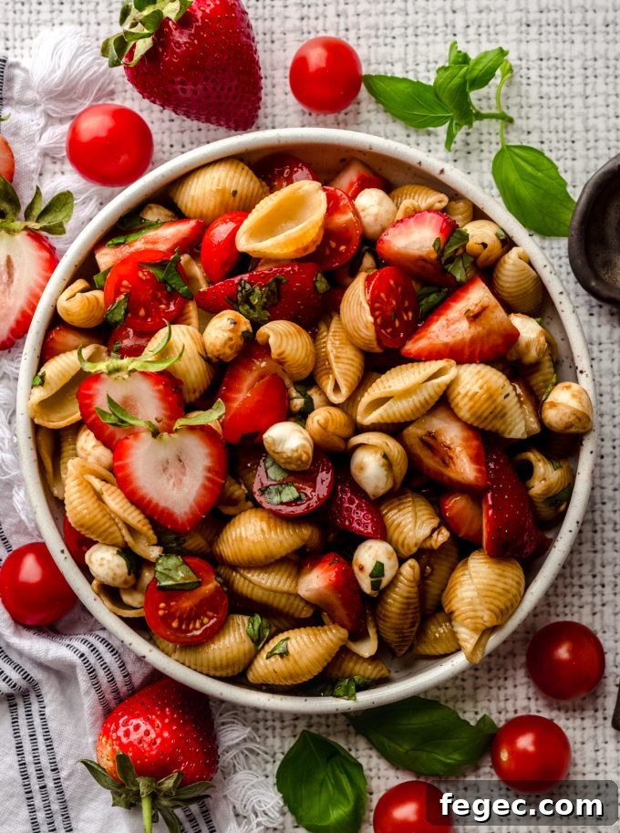 Aerial photo of strawberry caprese pasta salad in a bowl.