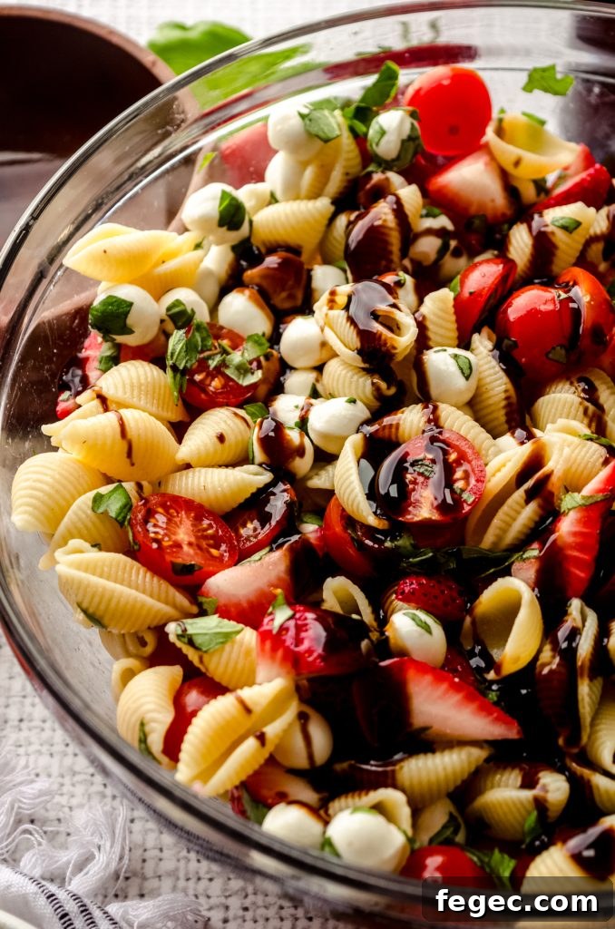 Closeup of strawberry caprese pasta salad in a bowl.