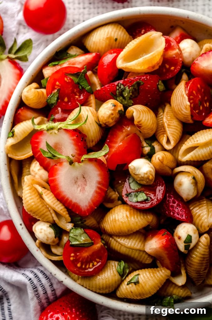 Closeup of strawberry caprese pasta salad in a bowl.