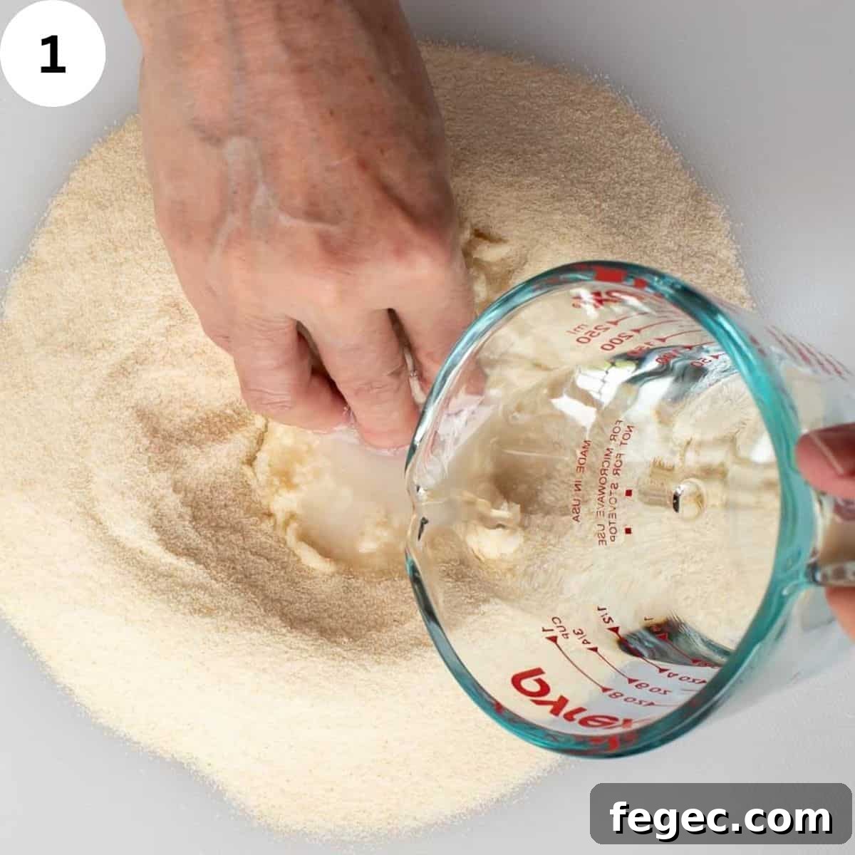 Mixing water into semolina with hands.