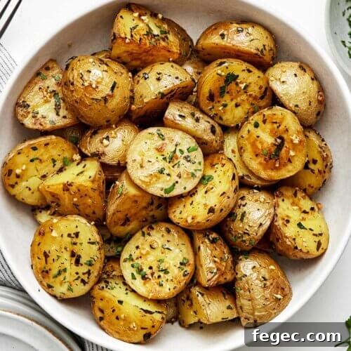 A white bowl of garlic roasted potatoes.