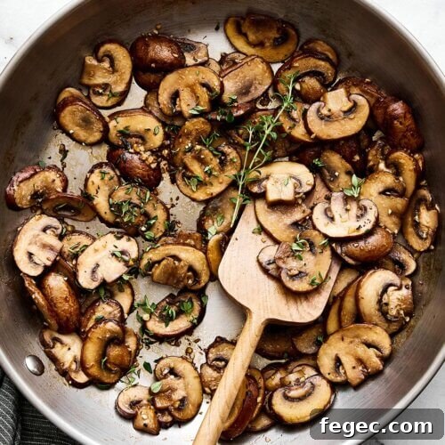 Sauteed mushrooms with thyme in a pan.
